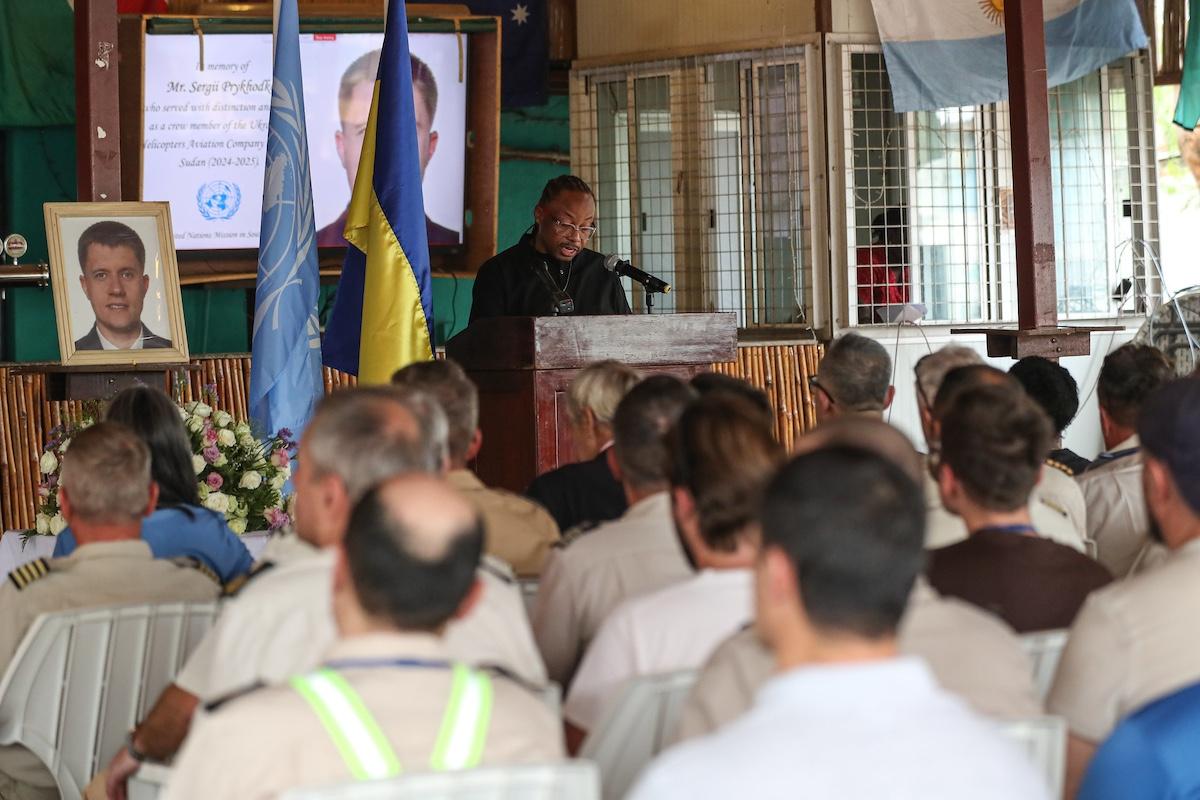 Sergii Prykhodko from Ukraine was killed in action on 7 March. At a memorial service in Juba, he was given a hero's farewell. Photos: Isaac Billy/UNMISS A group of people seated watching a person deliver an address at a podium in honour of a fallen peacekeeper.