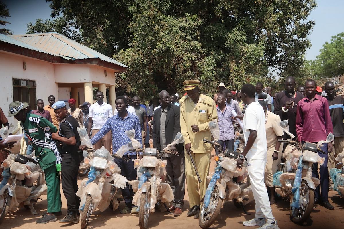 Kong Koc is a community-led peacebuilding project in greater Tonj, supported by the South Sudan Multi-Partner Trust Fund. Thirty-three motorcycles make up its latest contribution. Photos: Peter Ring Ariik Kuol/UNMISS A group of people standing in a line holding motorbikes